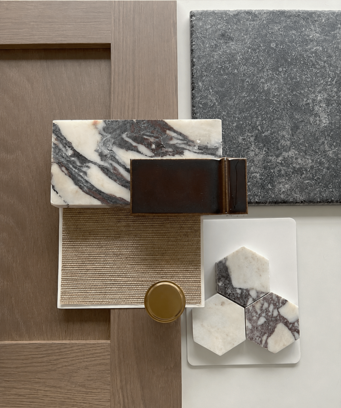 A curated studio sample board with marble, oak, terrazzo, bronze and ceramic finishes